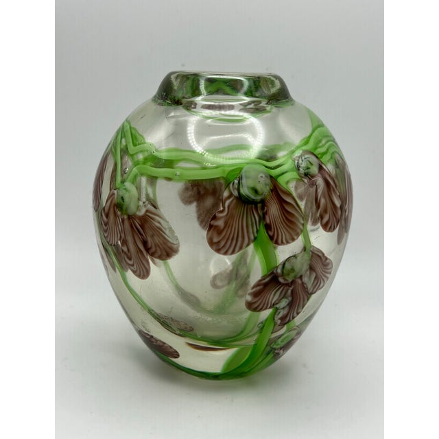 The object is a heavy art glass vase that encases an intricate floral motif- sweet pea vines. The floral vine is designed...