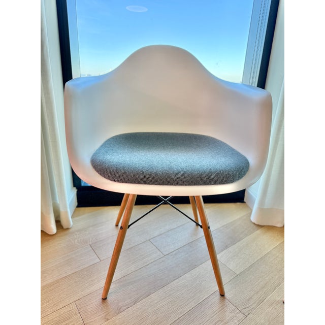 A Vitra/Eames original and design classic! Molded white dining armchairs with affixed grey-blue upholstered seat pads,...