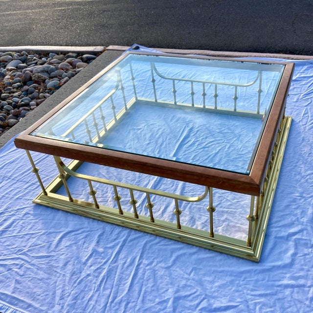 Large brass plated aluminum fireplace fender style plinth base under heavy beveled edge glass inset top, having hardwood...