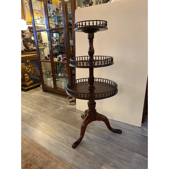 Antique Circa 1800-1820 solid mahogany three tiered dumb water table. The round tops with hand carved urn form rungs along...