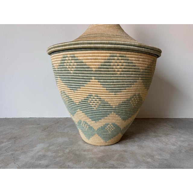 A beautifully handcrafted large vintage floor basket featuring a striking African-inspired silhouette and intricate...