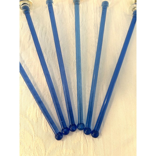 Retro set of six plastic clear blue swizzle sticks each featuring a colorful topper replica of a tropical cocktail....