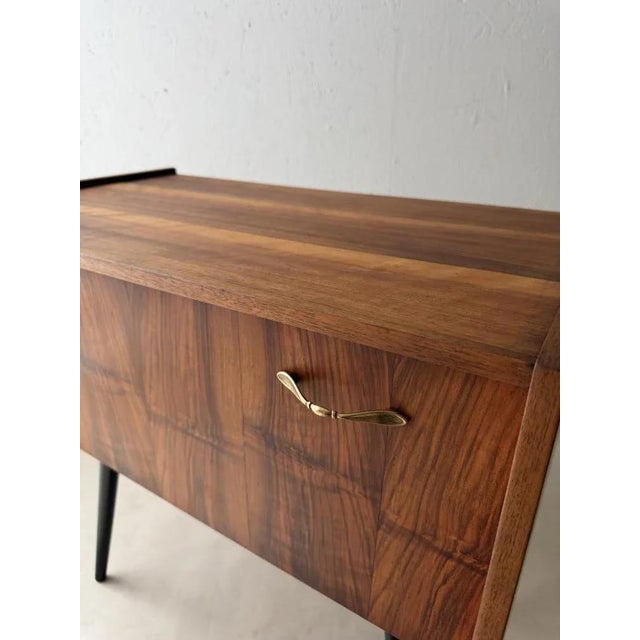 The strength of this piece of furniture lies in its proportions. The slender body appears to float between the side...
