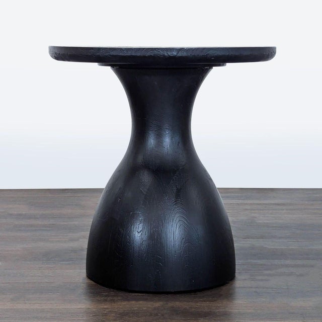 Inspired by the rounded, gourd-shaped tribal drums found throughout Africa, the table is crafted from blackened wood. It...