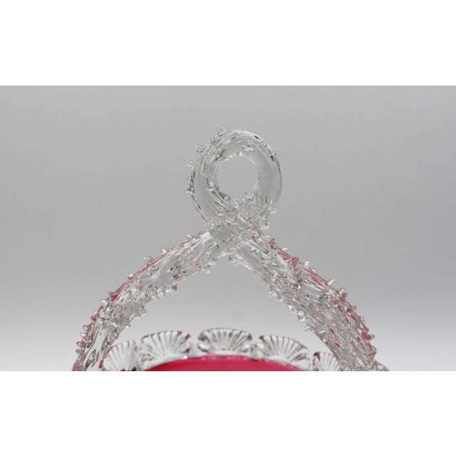 Circa 1880 cranberry glass bride's basket with clear handle, England. A tour de force of glass blowing with rare thorned...