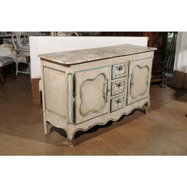 A French Louis XV period painted wood buffet with marbleized top, two doors and three drawers from the mid-18th century....