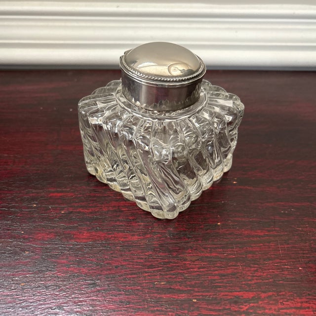 Antique heavy crystal ink well. Square in shape. Swirled glass design with silver plate lid that opens.