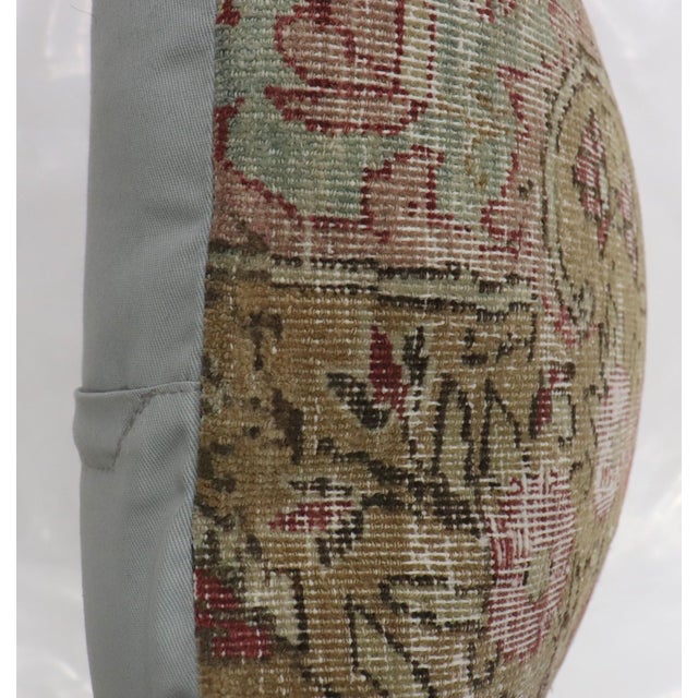 a pillow made from an early 20th-century worn persian pictorial rug
