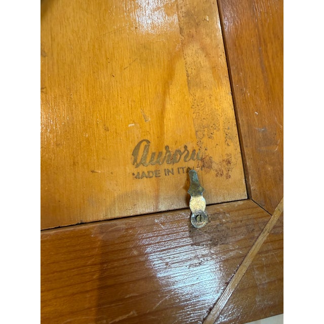 An Italian picture frame by Aurora, with a wide, mitered border in richly figured dark brown wood. Its warm finish and...