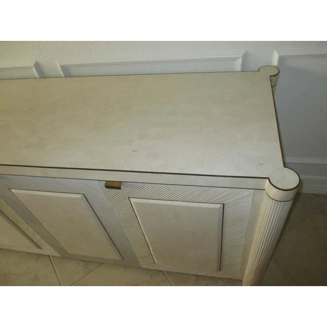 Split bamboo-over-wood sideboard with an ivory finish, tiled top, and brass accents. Each door has a tiled panel inset:...