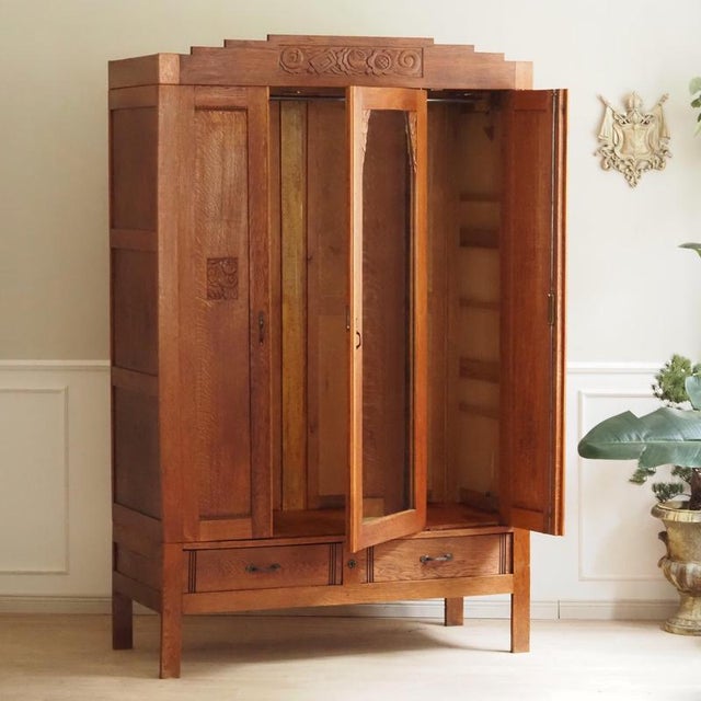 A three-door wardrobe made of solid oak, created during the transition from late Art Nouveau to early Art Deco, dating...