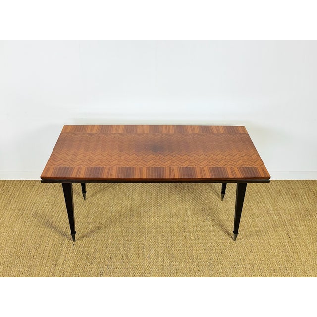 An elegant art deco table from the 1940s, featuring superb herringbone marquetry in the center of the tabletop. this...
