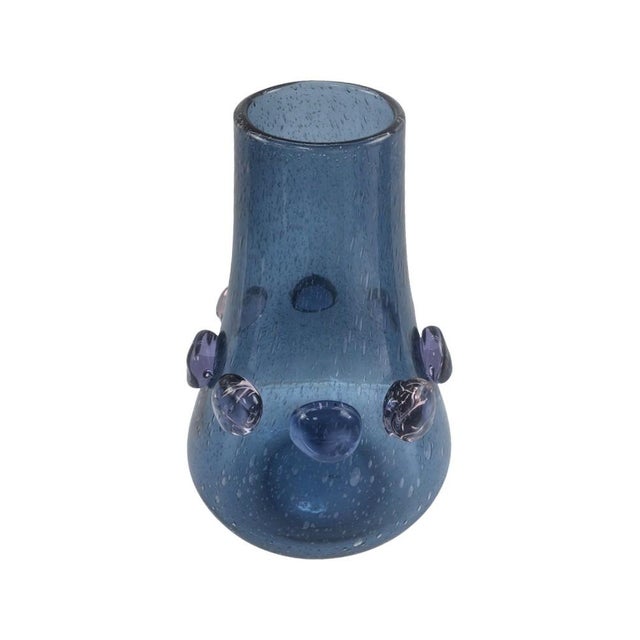The softly tapered silhouette features a rich blue tone enhanced with delicate bubble detailing within the glass. Raised...