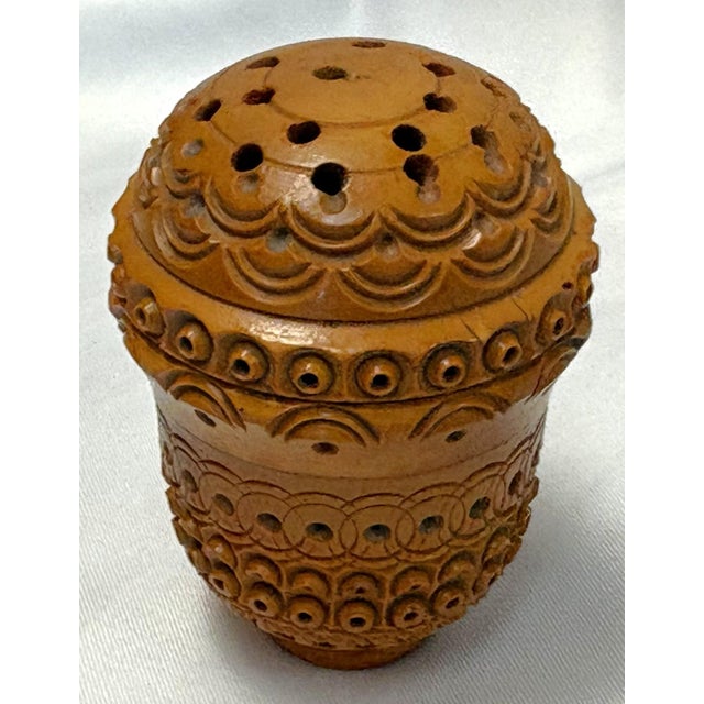 Precious petite wood box from the 19th century. The piece is hand made of wood with a threaded closure and several pierced...