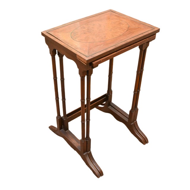 An elegant pair of English Regency Revival nesting tables, c. 1900-1930 and distinguished by beautifully figured burl...
