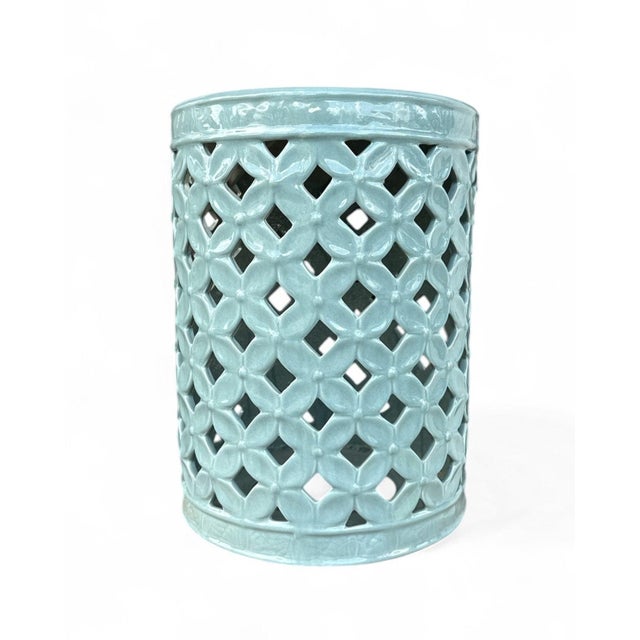 The Cherise Garden Stool is a ceramic garden stool with a cylindrical form and an allover flower-of-life pierced pattern...