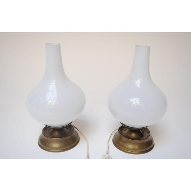 Pair of petite chamberstick/oil lamp-style bedside/table lamps (ca. 1950s, Italy). Composed of sculptural opaline glass...