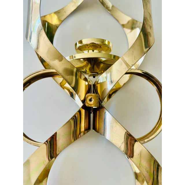 This vintage sconce from Mascot International showcases a blend of geometric form and polished brass. The design features...