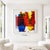The abstract artwork combines vibrant shades of red, yellow, and blue into a powerful, multi-layered composition....