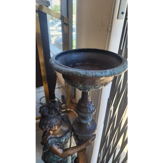 A pair of beautiful bronze cast female figure statues holding lamps, would make for wonderful outdoor decor.
