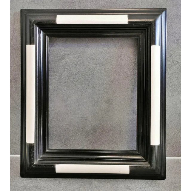 FRAME, arched and profiled frame moulding, ebonised and ivory coloured; model frame by the French manufactory " DELF -...