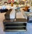 Distinctive sofa featuring a rich brown/tan leather seat and a dark wood frame, complemented by built-in shelving along...