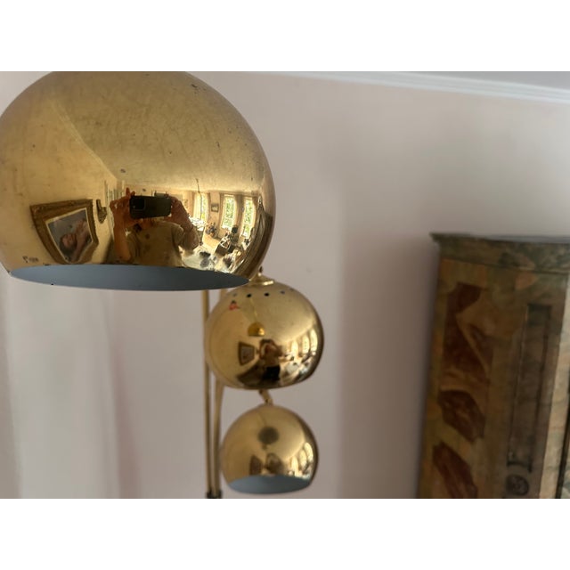This striking 1970s brass arc floor lamp features three individually adjustable curved arms, three spherical shades and a...
