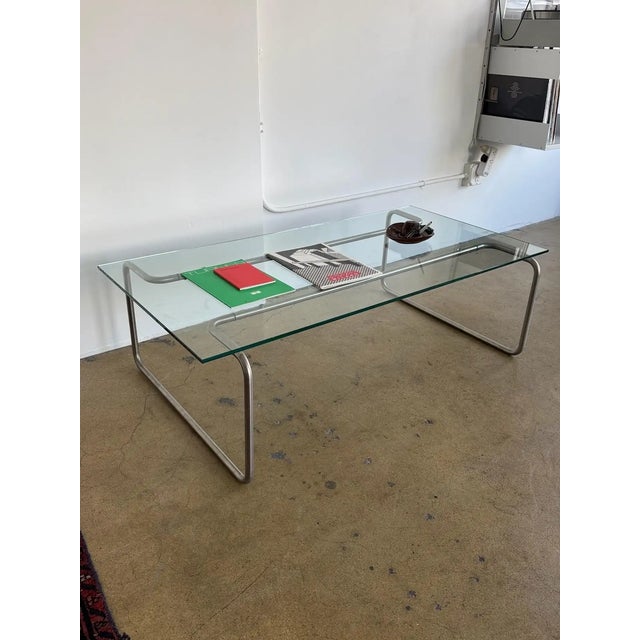 Bent tubular steel and glass coffee table. 1980s style. Bauhaus-inspired lines with a low architectural profile. Maker...