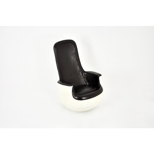 High-back armchair in black leather with a molded fiberglass shell. The chair can be reclined. Wear consistent with age...