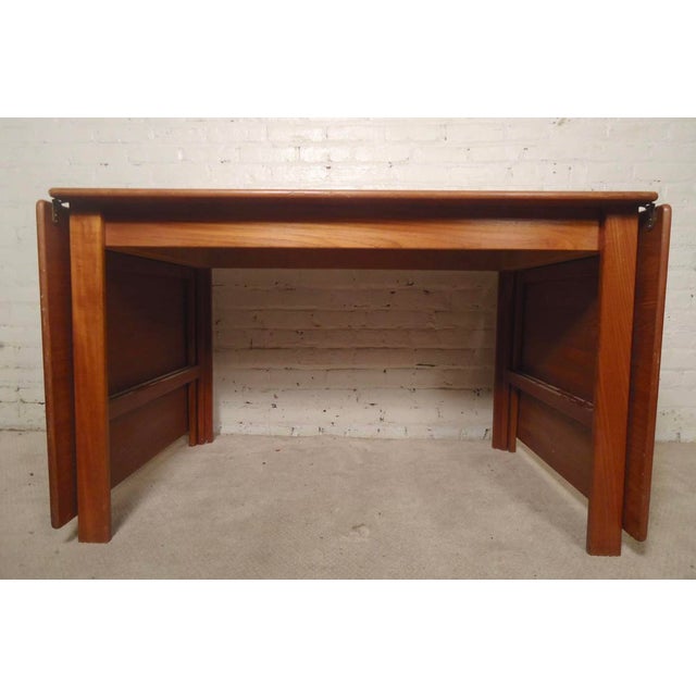 Danish modern dining table with two long leaves. Both leaves hang or can be taken off for a four person table, or extended...