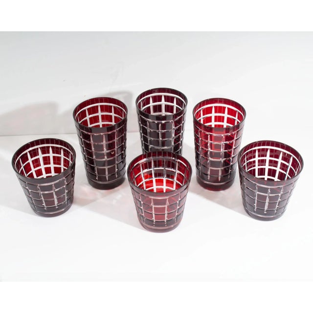 A set of six red cut to clear glasses. Included are three tall glasses and three tumblers. Each glass has a red cut to...