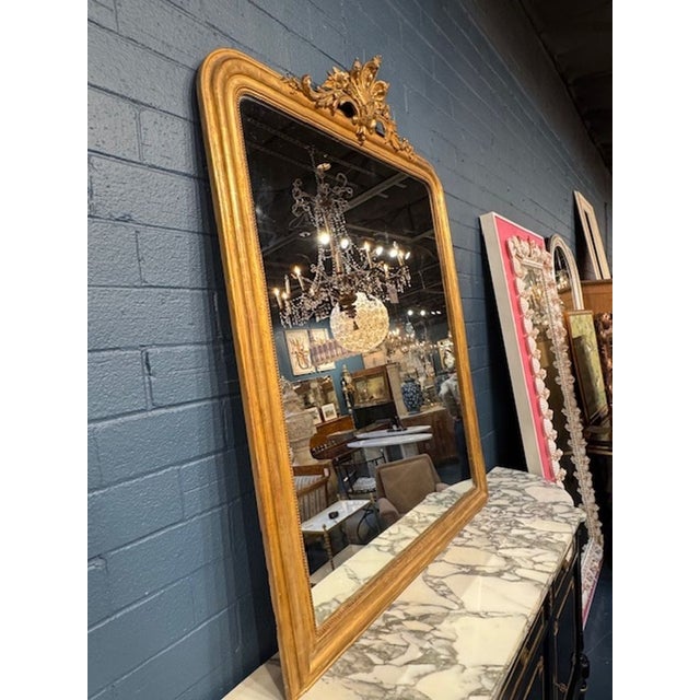 Large 19th century French Louis Philippe giltwood mirror with crest. Louis Philippe mirrors are known for their rounded...