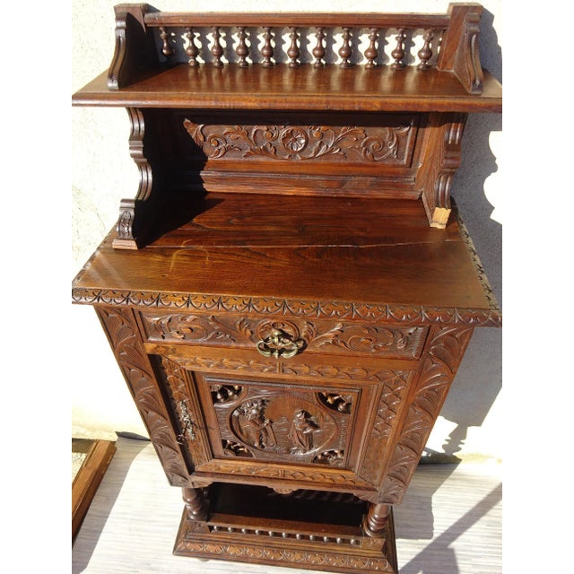 Small French storage cabinet, finely hand-carved. from Brittany, with a scene of everyday life in bas-relief. Old Bedel et...