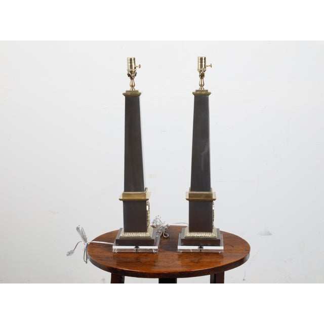 A pair of French steel and brass table lamps from the mid 20th century, with lucite bases. Created in France during the...