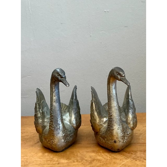 Sculpted with graceful arched necks and poised upward-swept wings, this vintage pair of cast metal swan figurines captures...