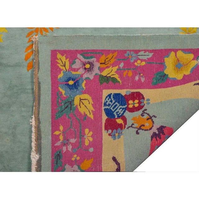 A brilliant Chinese Art Deco rug with an unusual color palette of pinks, fuchsia, gold, orange, and lavender on a pale...