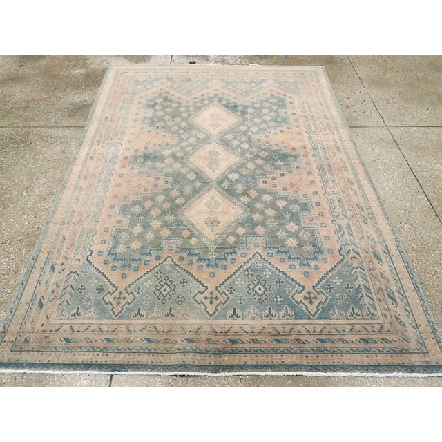 This mid-20th-century Persian Afshar accent rug presents a softly geometric composition in muted blue, pale peach, ivory,...