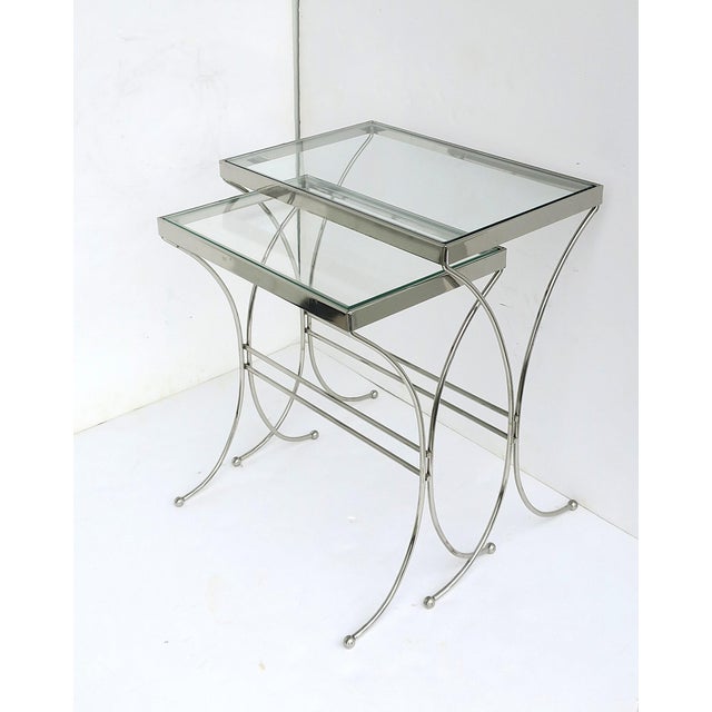 A set of chrome and glass nesting end or side tables, Mid‑Century Modern design, circa mid‑20th century. A set of...