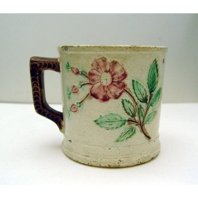 Lovely old majolica mug with impressed roses. Couple small chips along lip.