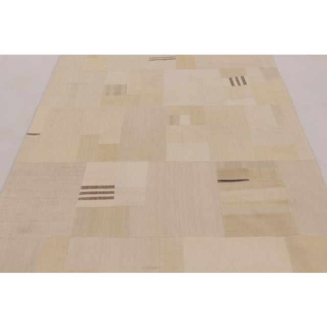 Handwoven in wool and cotton and originating circa 1950–1960, this 6x8 vintage Turkish patchwork rug is a refined example...