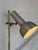 This sleek floor lamp features an adjustable spotlight shade mounted on a slender stem. The minimalist design offers...