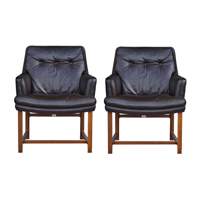 A pair of Brown Leather Lounge Chairs from Dunbar Tufted brown leather upholstery Wooden legs Price is for the pair, three...