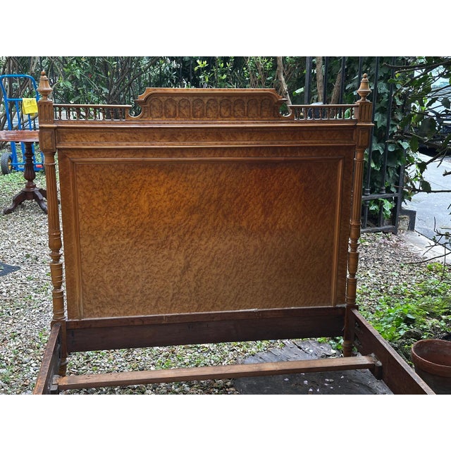 Antique bed in burr wood veneer, showcasing a rich and luminous grain typical of the 19th century. Its panels framed with...