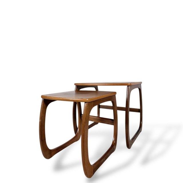 A classic mid-century Nathan nest of tables, showcasing the brand’s signature warm teak tones and elegant sculptural...