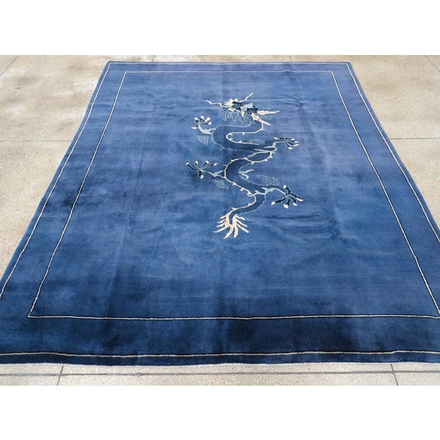 This Mid-20th century Chinese Peking Art Deco rug, is a striking example of the bold design and rich color palette...