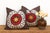 A radiant orange-gold starburst sits at the center of each pillow in this well-matched pair, ringed first in red and then...