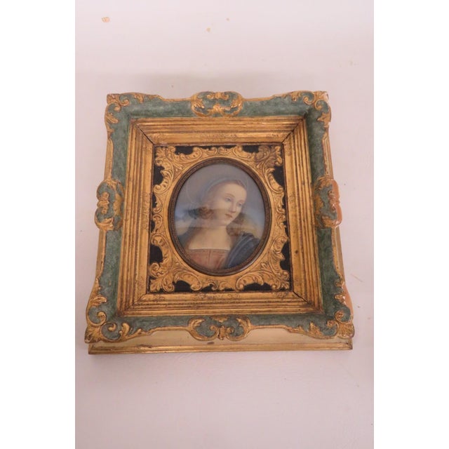 This lovely Hanging Artwork is framed in wood. This wonderful artwork is a reproduction of the portrait of the Madonna...