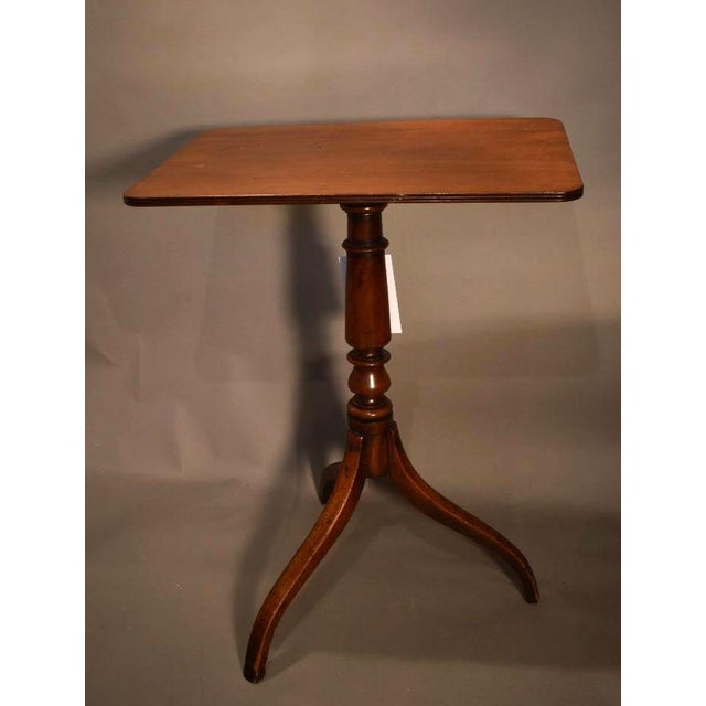 English Mahogany Late Georgian tilt top candle stand. A rectangular top with rounded corners rests on a well turned stem...