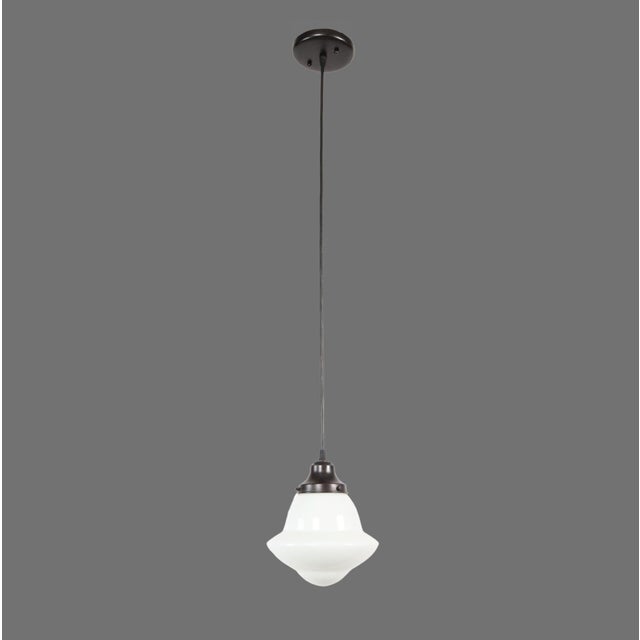 1920s Schoolhouse style pendant light made of an antique milk glass globe and a newly made black wire cord fitter. This...