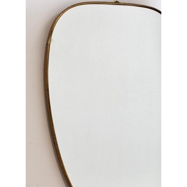 Mid-Century Italian wall mirror with brass frame (circa 1950s). This mirror is simply elegant and characterful in a...